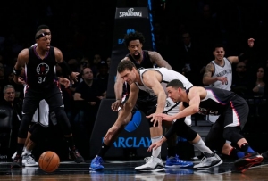 Brooklyn Nets center Brook Lopez trying to defend the ball against Los Angeles Clippers players