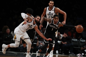 Brooklyn Nets guard D’Angelo Russell pushing the ball trying to get away from Utah Jazz defenders Ricky Rubio to the left and Rudy Gorbert on the right.