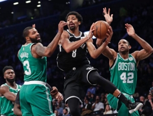 Spencer Dinwiddie (center) protecting the ball to pass around Marcus Morris (left) and Al Horford (right)