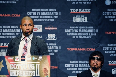 Professional boxer Miguel Cotto speaking at the podium during a press conference about his upcoming fight with Antonio Margarito (seated) at the Edison Ballroom on September 20, 2011 in New York City.