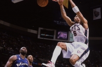 Former Nets player Kenyon Martin retires from the NBA; shown here hanging onto the basketball rim while Washington Wizards players look on.
