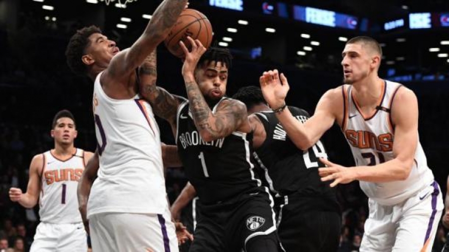 D&#039;Angelo Russell, who led all scorers with 33 points in Nets loss to the Phoenix Suns, defending the ball against two Phoenix players