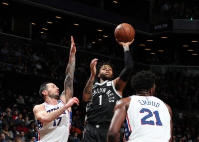 D&#039;Angelo Russell, Brooklyn Nets point guard shooting ball over JJ Redick on left and Joel Embiid on right.