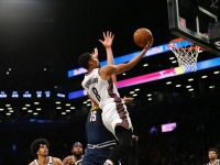 Brooklyn Nets guard, Spencer Dinwiddie, goes for a layup with Denver's Nikola Jokic defending at the Barclays Center on December 8, 2019. Brooklyn Nets defeat the Denver Nuggets 105-102.