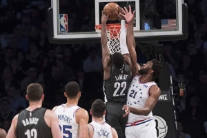 Caris LeVert, Brooklyn Nets guard, dunks ball despite the defensive efforts of Joel Embiid of the Philadelphia 76ers during Game 4 of the first round of the NBA Playoffs at Barclays Center on April 20, 2019. 