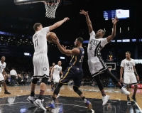 Brooklyn Nets center Brook Lopez (11) on left and Isaiah Whitehead (15) on right, surround Indiana Pacers forward Thaddeus Young (21).