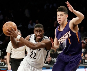 Caris LeVert of Brooklyn Nets being guarded by Phoenix Suns Devin Booker on March 23, 2017. Nets win 126-98